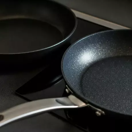 imgi_208_Two_frying_pans_side_by_side_on_a_kitchen_countertop.webp